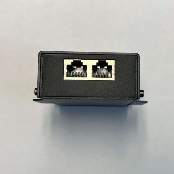 Ein schwarzes Netzwerkgerät mit zwei RJ45-Ethernet-Anschlüssen an der Vorderseite, das auf einer ebenen Fläche montiert wird. Es hat ein einfaches rechteckiges Design und ist aus Metall oder robustem Kunststoff gefertigt, mit einer kleinen Halterung an einer Seite. Der Hintergrund ist eine weiche weiße Oberfläche.