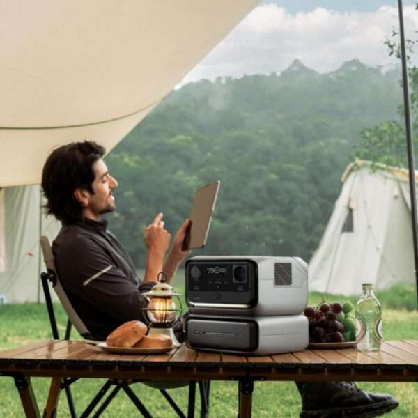 Ein Camping-Szenario mit einem Mann, der auf einem Tablet sitzt, im Freien vor einem Zelt. Weiches, natürliches Licht, grüne Landschaft im Hintergrund, gemütliche Atmosphäre.