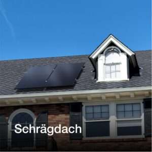 Ein Wohnhausdach mit dunkelgrauen Schindeln und zwei schwarzen Solarmodulen, die auf einem schrägen Abschnitt montiert sind. Darüber hebt sich ein Ziergiebel mit einem weißen Fenster von der Dacheindeckung ab. Der klare blaue Himmel dient als Hintergrund. Der Schriftzug Schrägdach ist am unteren Rand angebracht.