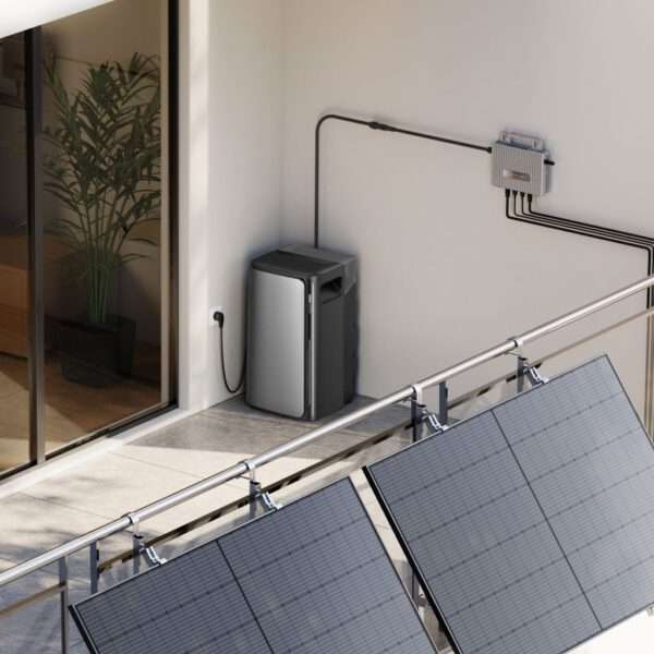 Ein moderner Balkon verfügt über große Sonnenkollektoren, die an einem Geländer angebracht sind. In der Ecke ist eine elegante, graue Energiespeichereinheit über sichtbare Kabel mit der Solaranlage verbunden. Hinter der Einheit sorgt eine grüne Topfpflanze für einen Hauch von Natur, während eine große Glasschiebetür den Zugang zum Innenraum ermöglicht. Die Umgebung ist gut beleuchtet, was auf einen hellen, sonnigen Tag hindeutet.